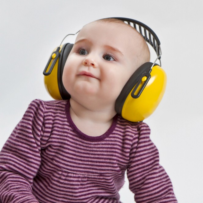 imagine bebe mic se uita in lateral si are casti antifonice pe cap