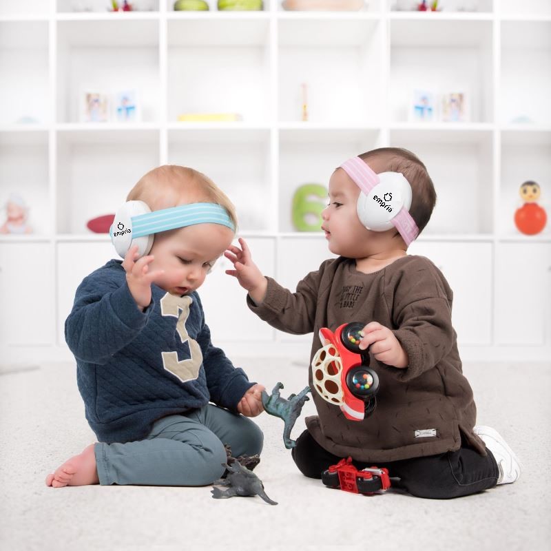 doi copii mici care se joaca si au casti antifonice empria pe cap