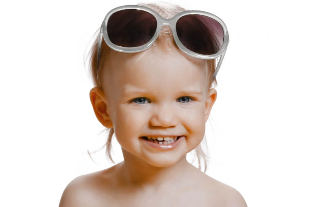 copil mic cu ochelari de soare pe cap si zambet mare