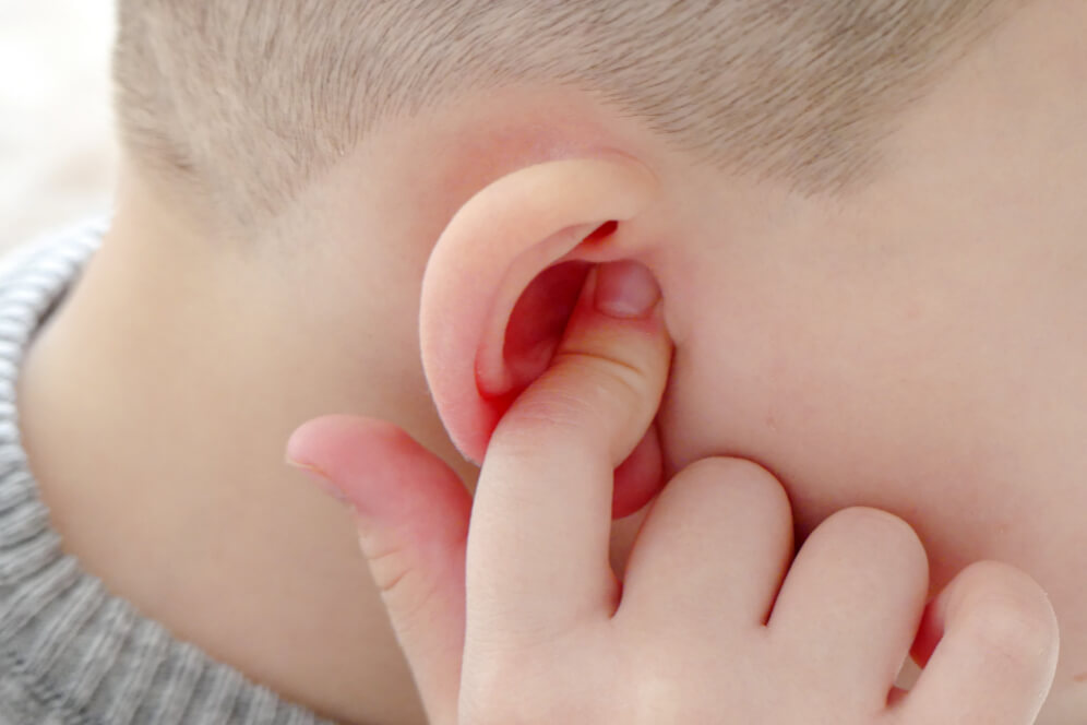 copil care isi baga degetul in ureche