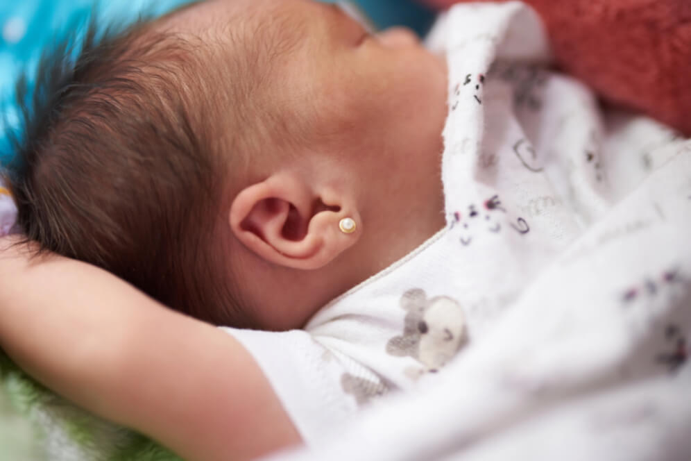 bebelus dormind cu cercel in ureche